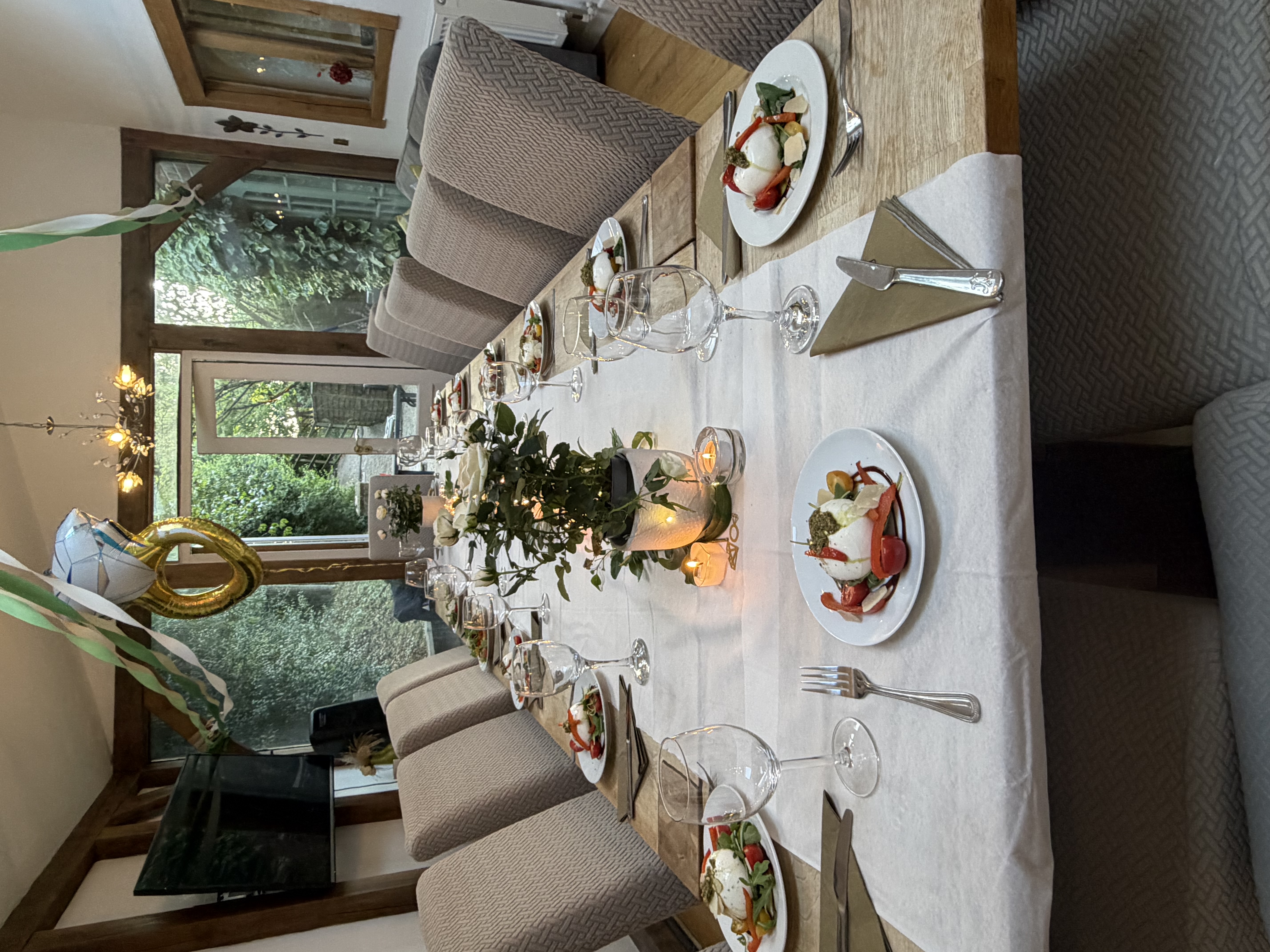 Elegant fine dining table setting with plated courses, glassware and candlelit centrepiece